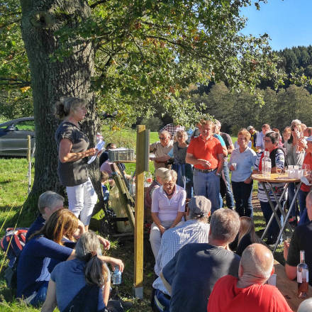Vera Schliefer trägt den Wanderern an der Friedenseiche ihre Erzählung vor.